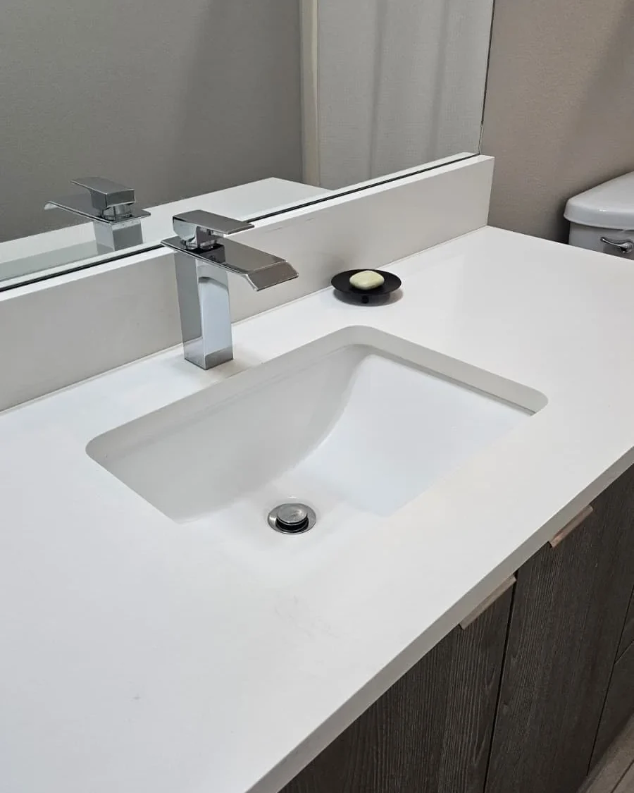 Freshly cleaned bathroom sink, mirror, and vanity countertop in a Vancouver area home