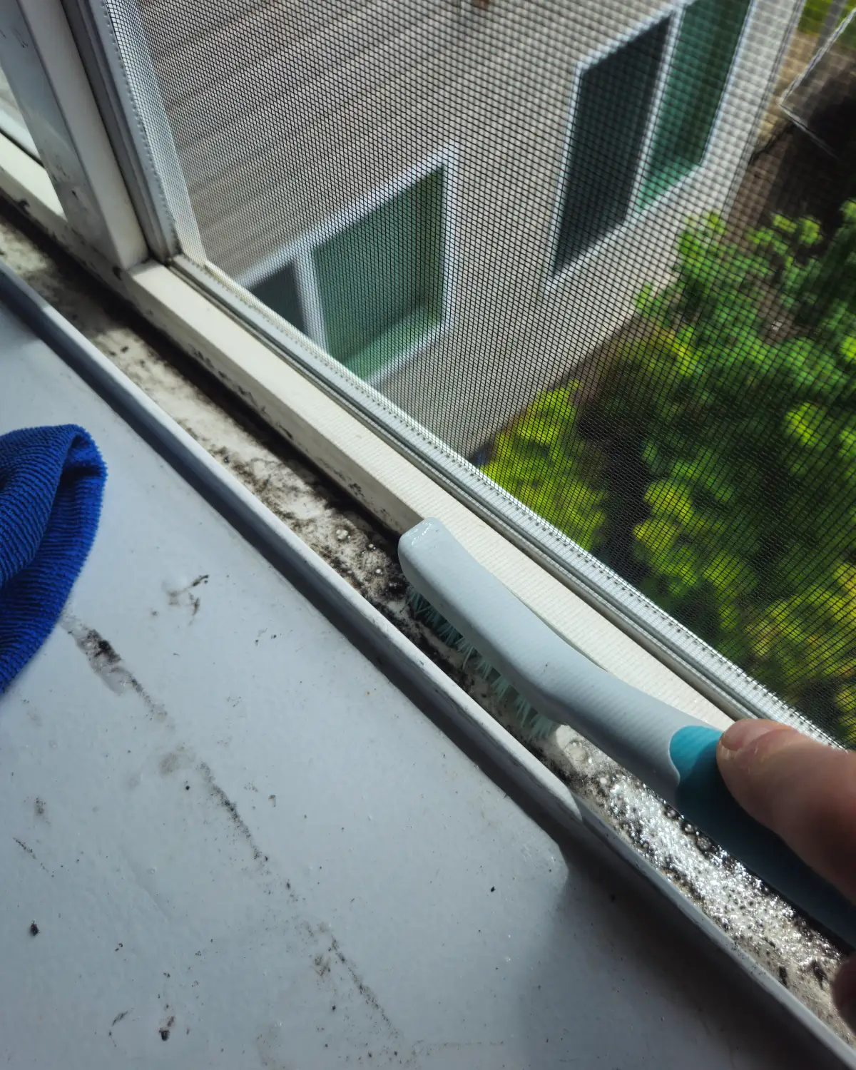 Before photo of an apartment bedroom window track with years of built-up dirt and debris