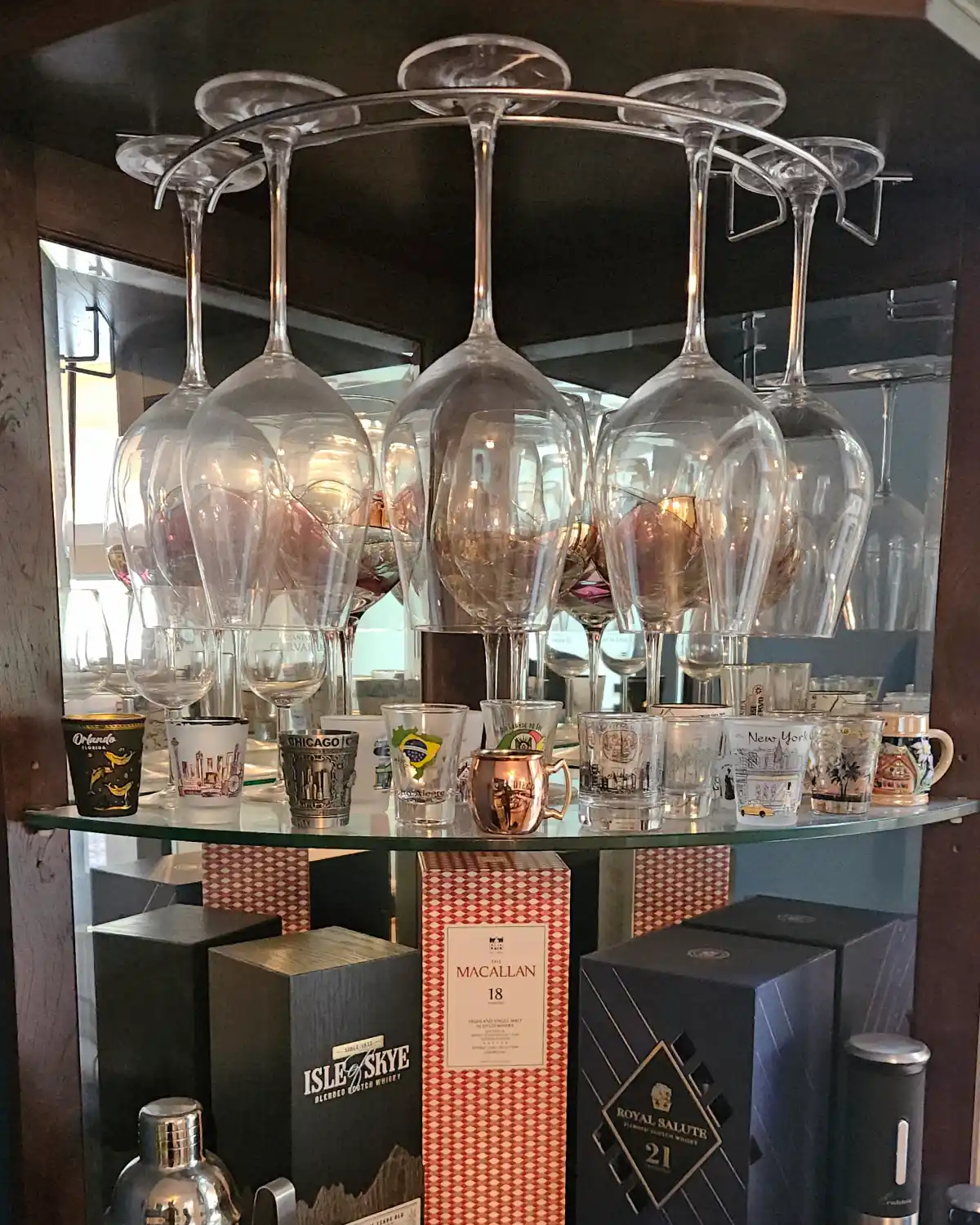 Before photo of a dust-covered china cabinet with wine glasses before careful hand cleaning