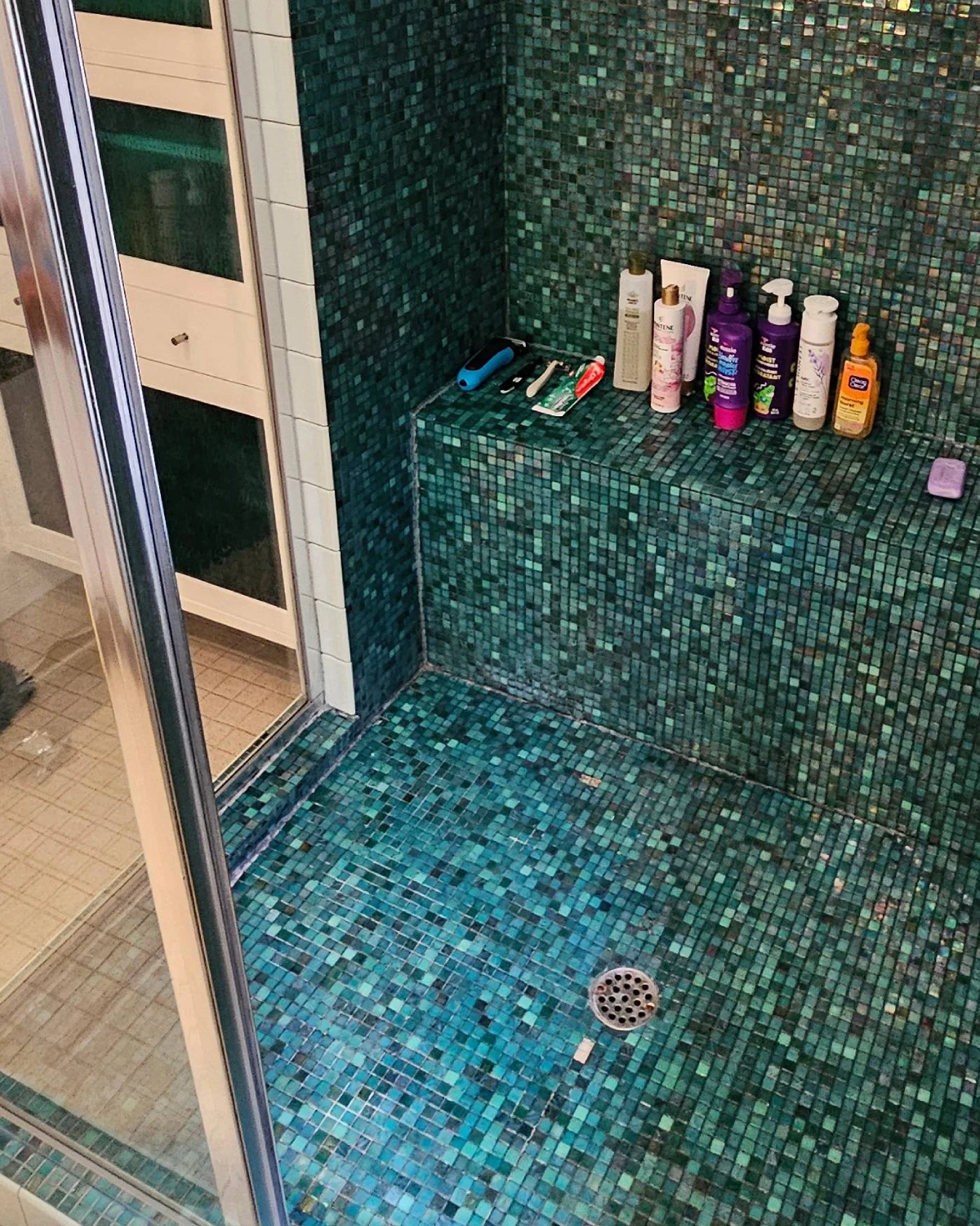 Clearer shower glass and clean green mosaic tile after soap scum removal by Clary Clean
