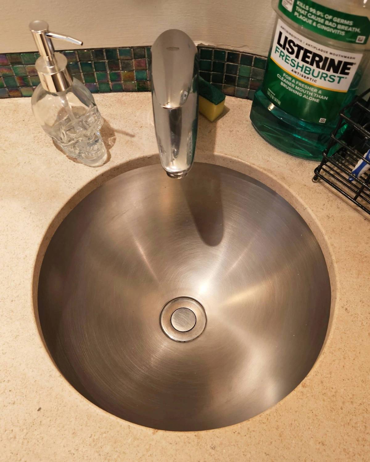 Clean, polished stainless steel bathroom sink and faucet after buildup removal by Clary Clean