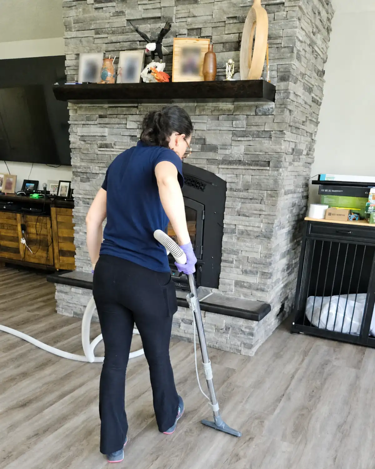 Cleaning professional vacuuming a living room floor during a house cleaning visit