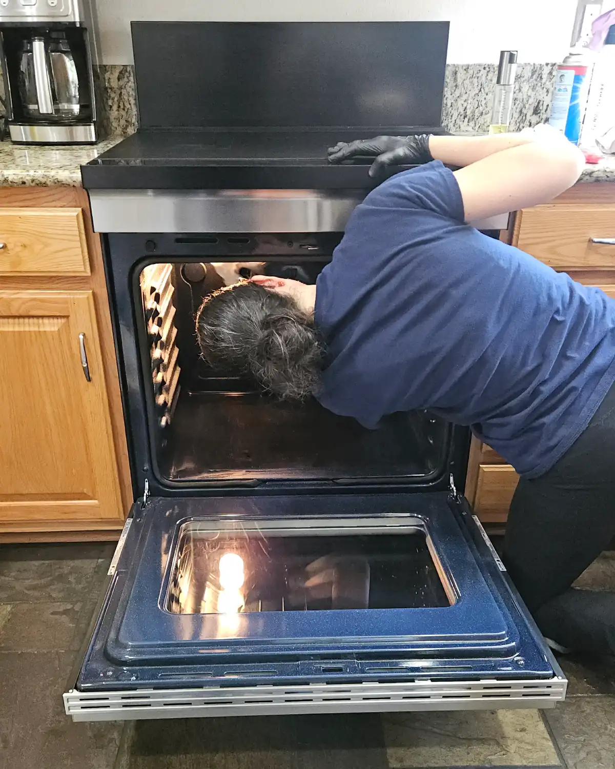 Cleaning professional carefully detailing the inside of an oven during a house cleaning visit
